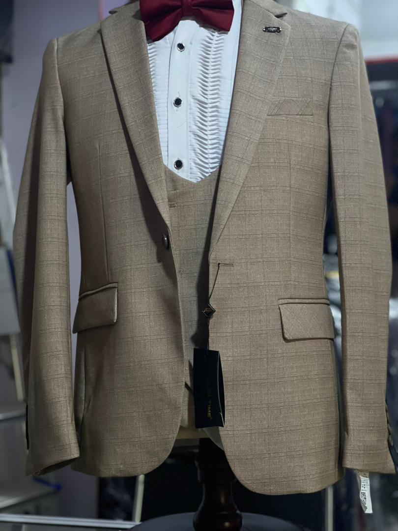Grey check three-piece suit features a slim-fit cut